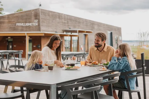 Familie spiser middag på terrassen