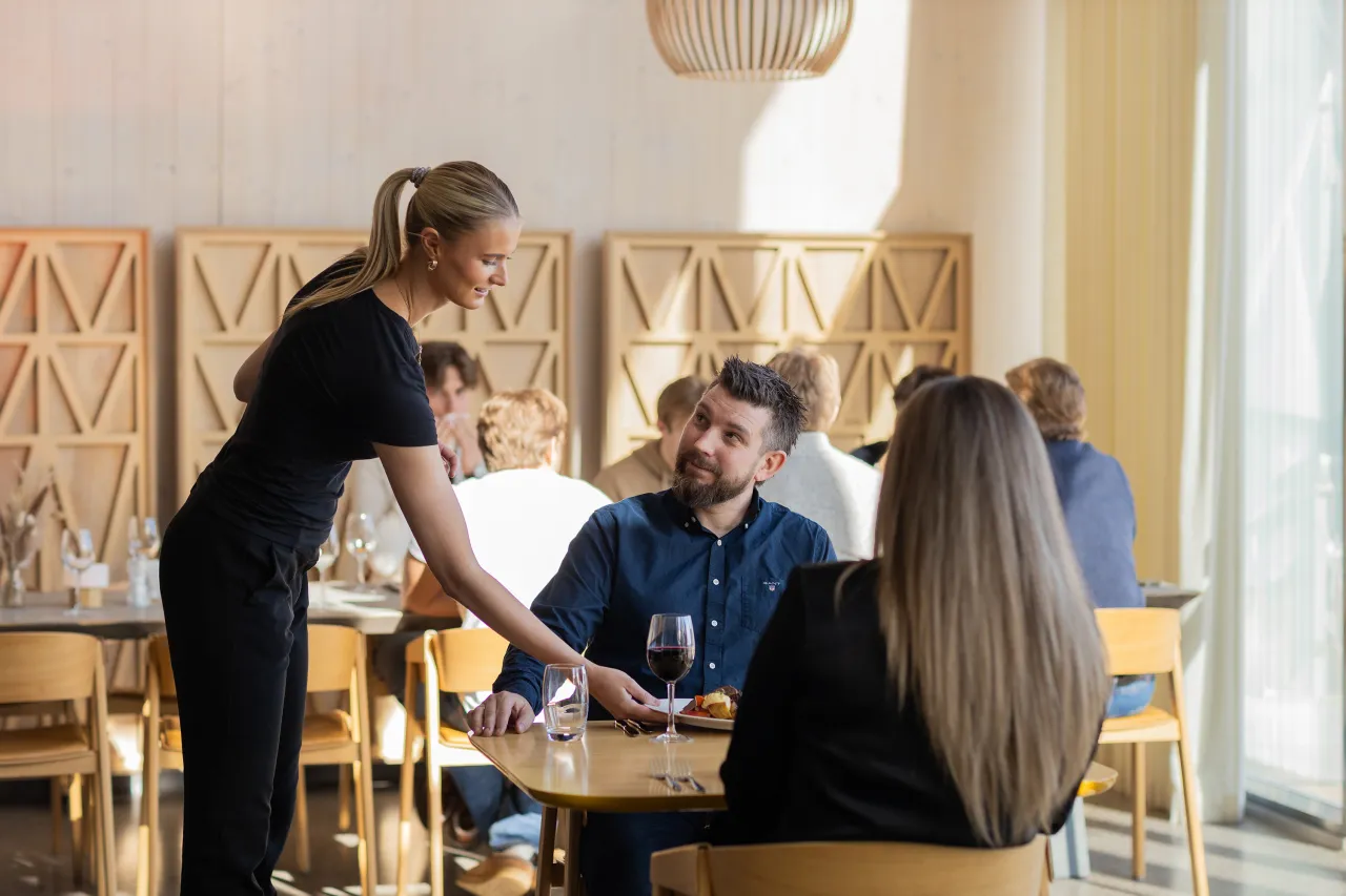 Servitør serverer par i restaurant